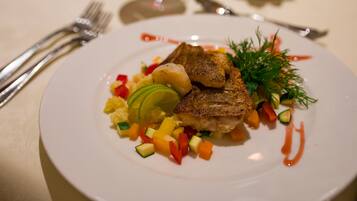 Un plato de comida con carne, verduras y una guarnición.