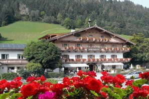 Un bâtiment de style chalet traditionnel, sur lequel on peut lire l’inscription « Dorfperwirt ».