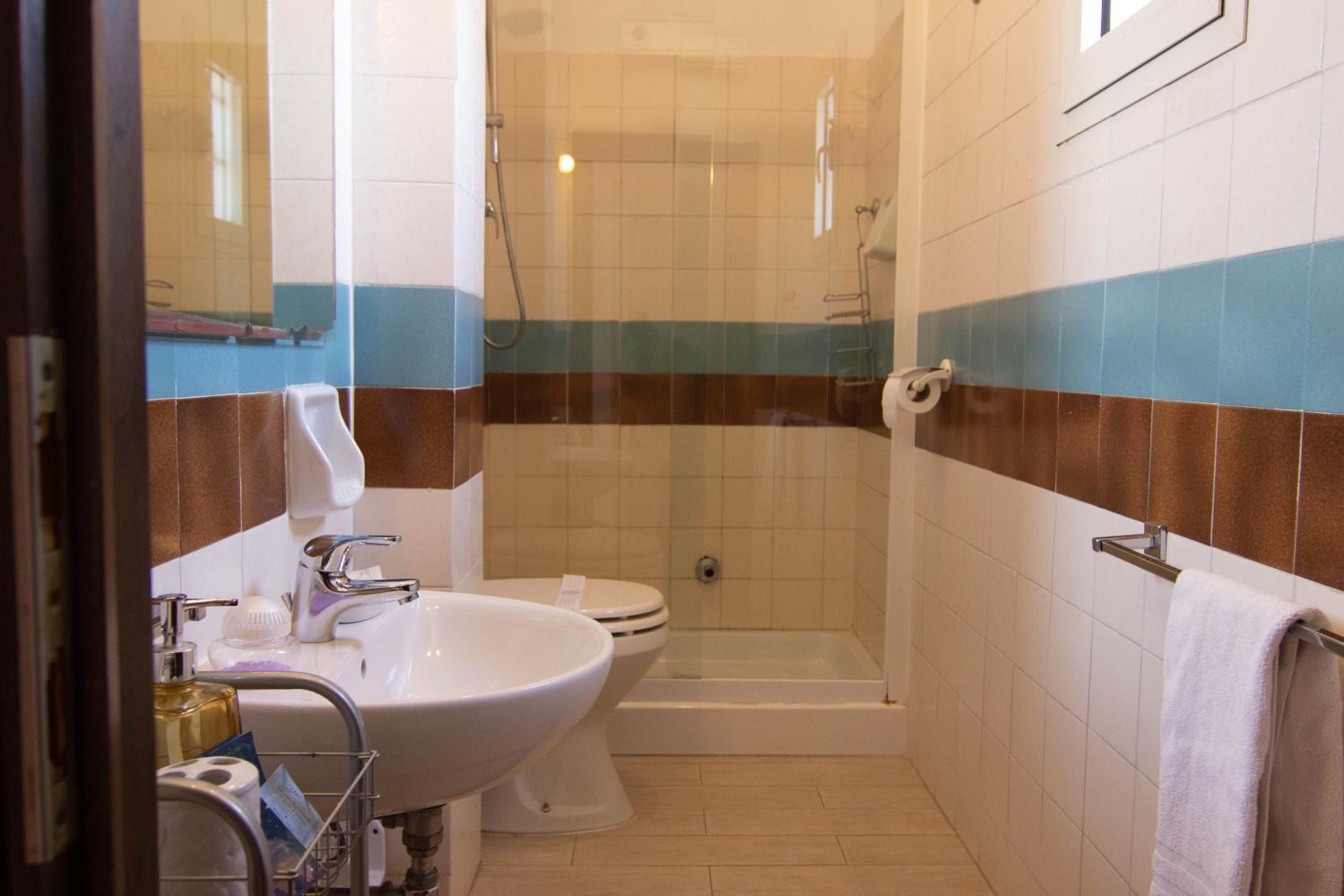 A bathroom with a sink, toilet, and shower.