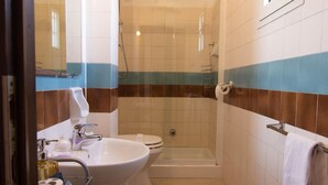 A bathroom with a sink, toilet, and shower.