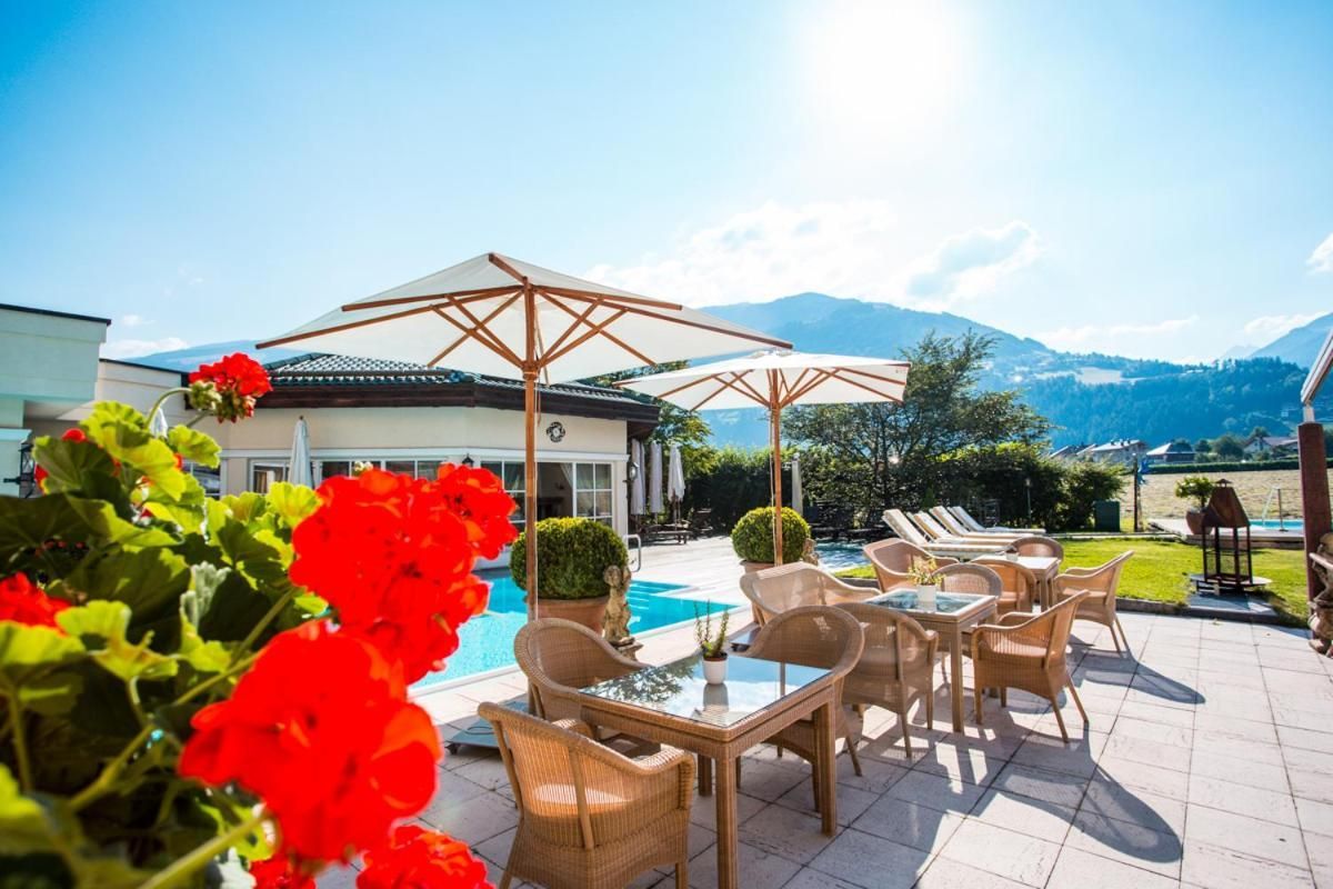 A poolside area with outdoor furniture and a view of mountains.