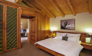 Ein Schlafzimmer aus Holz mit einem Bett, einem Nachttisch, einer Lampe und einem Gemälde an der Wand.