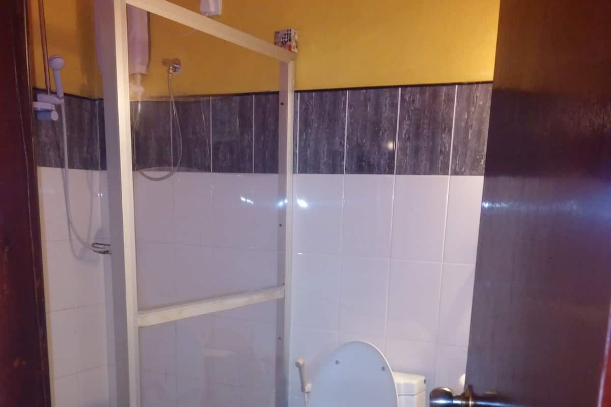 A bathroom with a toilet, a shower, and a sink.