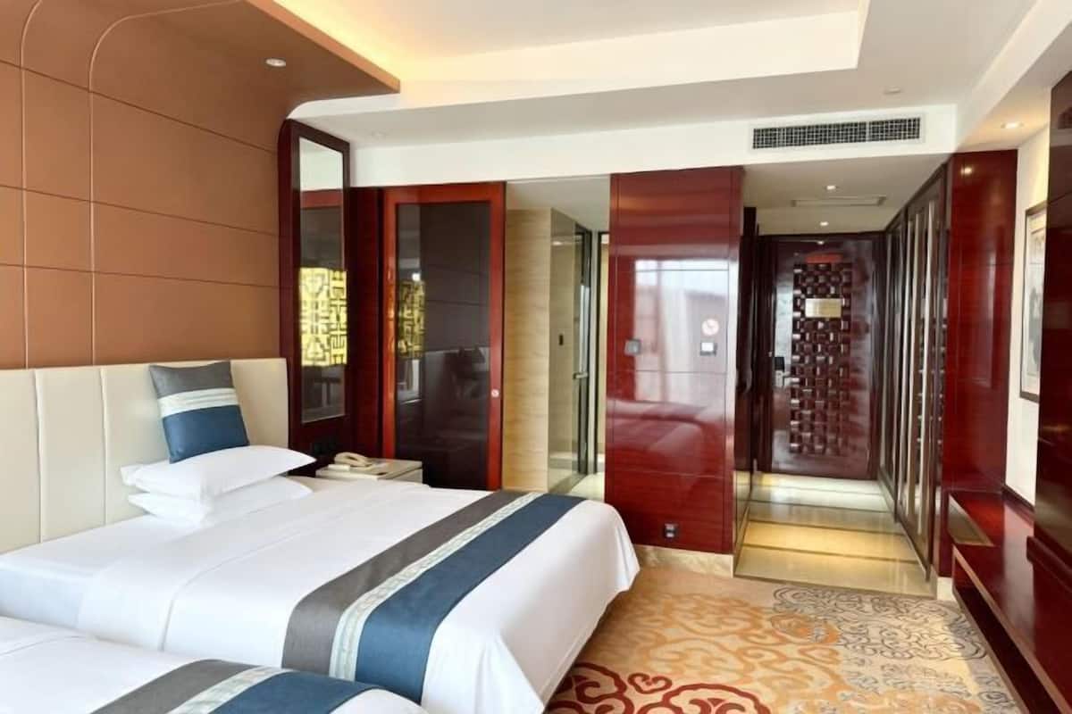 Una habitación de hotel con una cama grande, un escritorio y un vestidor.