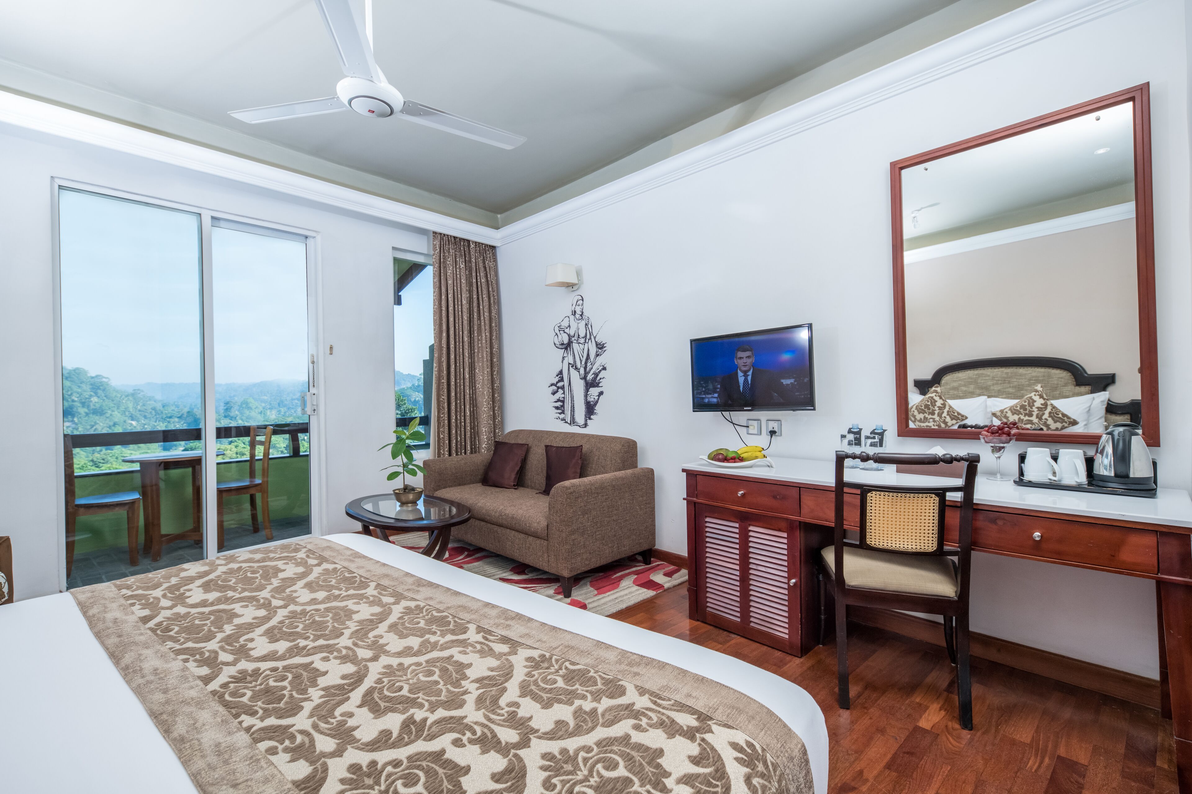 A hotel room with a bed, a desk, a chair, a television, and a balcony with a view.