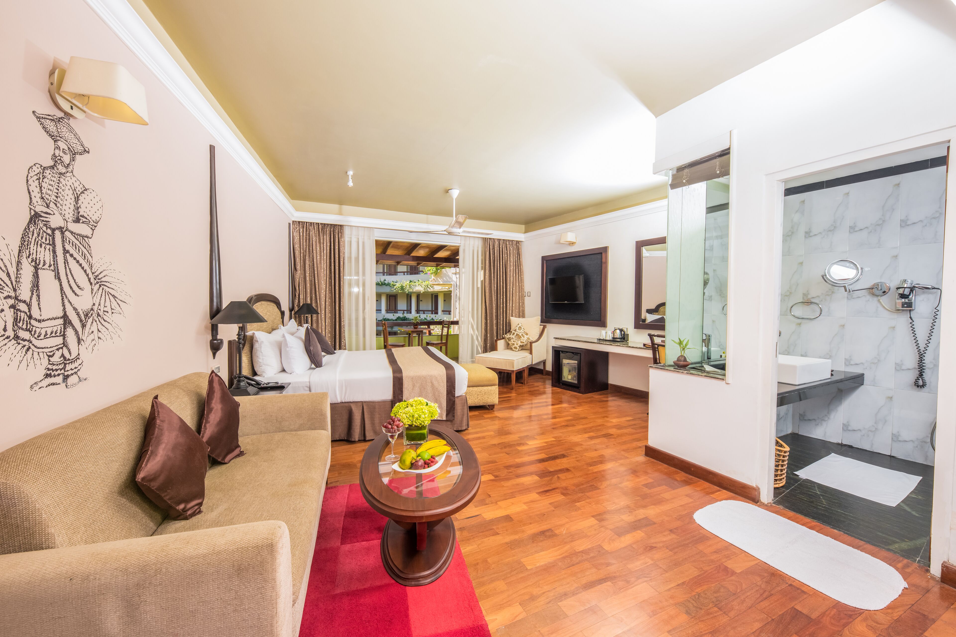 Ein Hotelzimmer mit Bett, Sofa, Essbereich und Badezimmer.