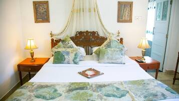 A bed with a canopy, two bedside tables with lamps, and a floral bedspread.