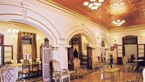 A grand lobby with ornate chandeliers, a long dining table, and classic furniture. - Manor House, Kandy, LKA (Harispattuwa)