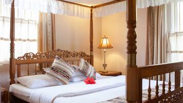 A four-poster bed with a wooden frame and white bedding.