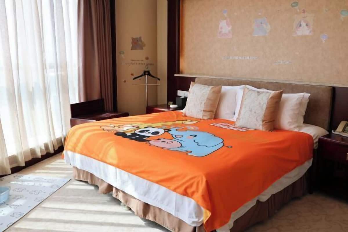 A hotel room with a bed, curtains, a bedside table, a nightstand, and a wall with artwork.