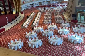 A large banquet hall with multiple round tables arranged in rows, a red carpeted floor, and a high ceiling with architectural details. - Long Wish Hotel International (Jiangyin)