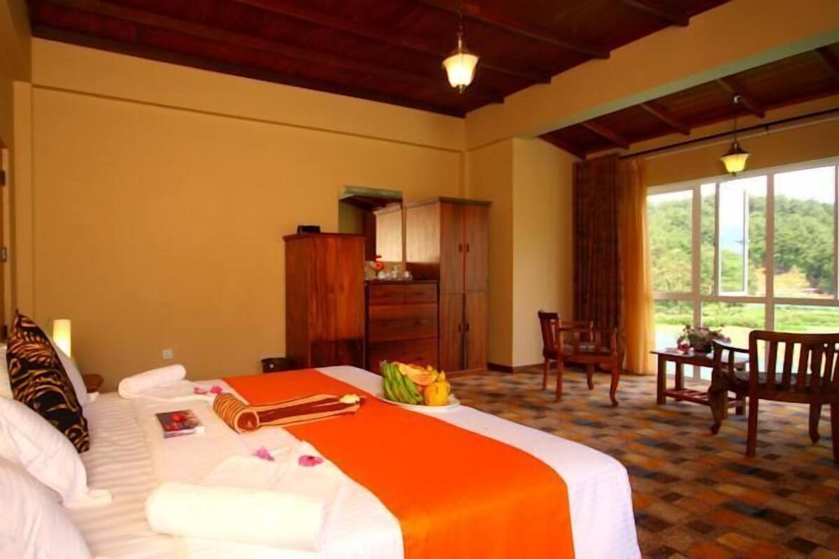 A hotel room with a bed, a desk, and a view of the outdoors.