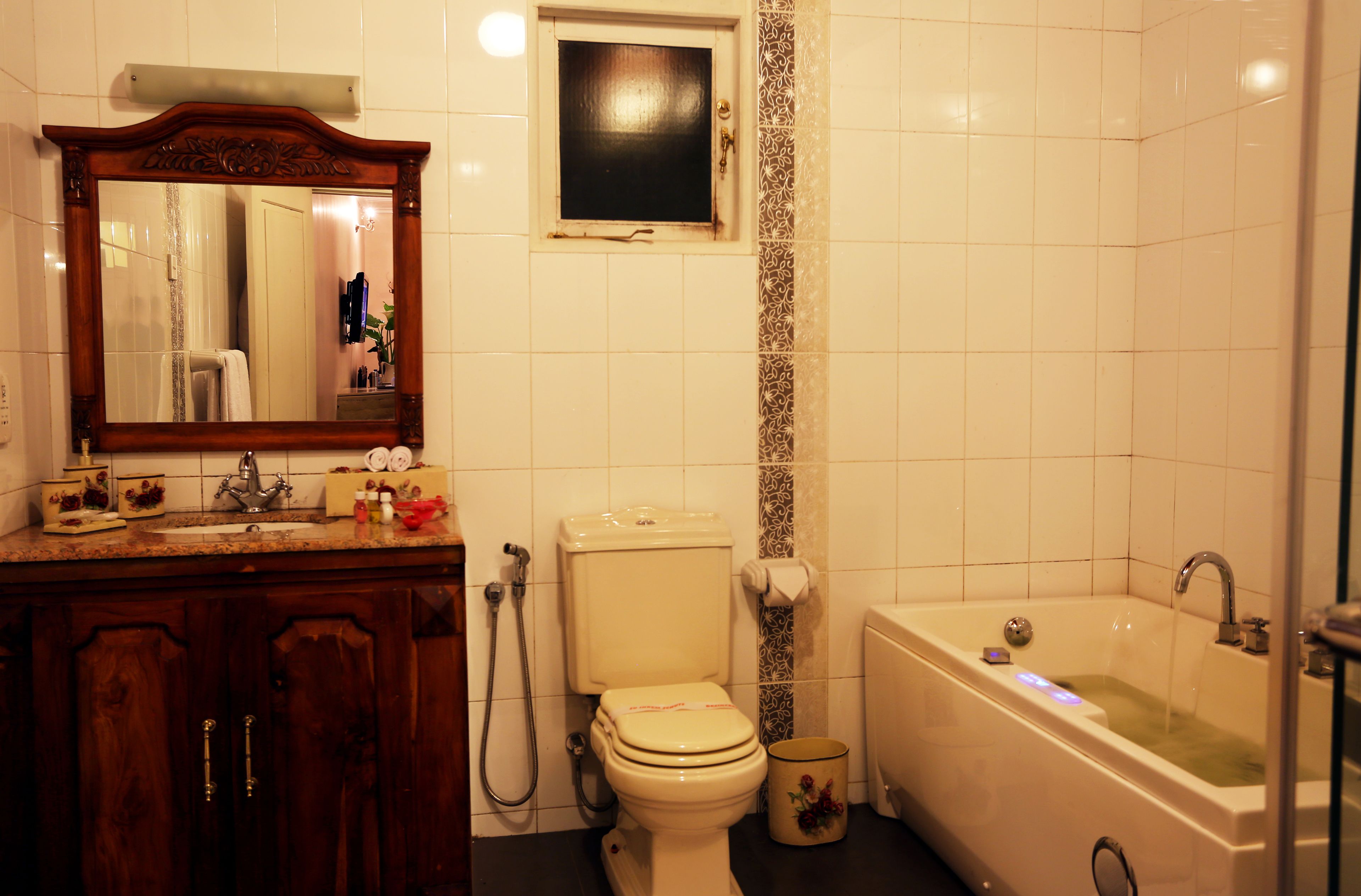 A bathroom with a toilet, sink, vanity, and bathtub.