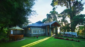 A house with a stone exterior, a tiled roof, and a well-maintained lawn. - The Firs (Nuwara Eliya)