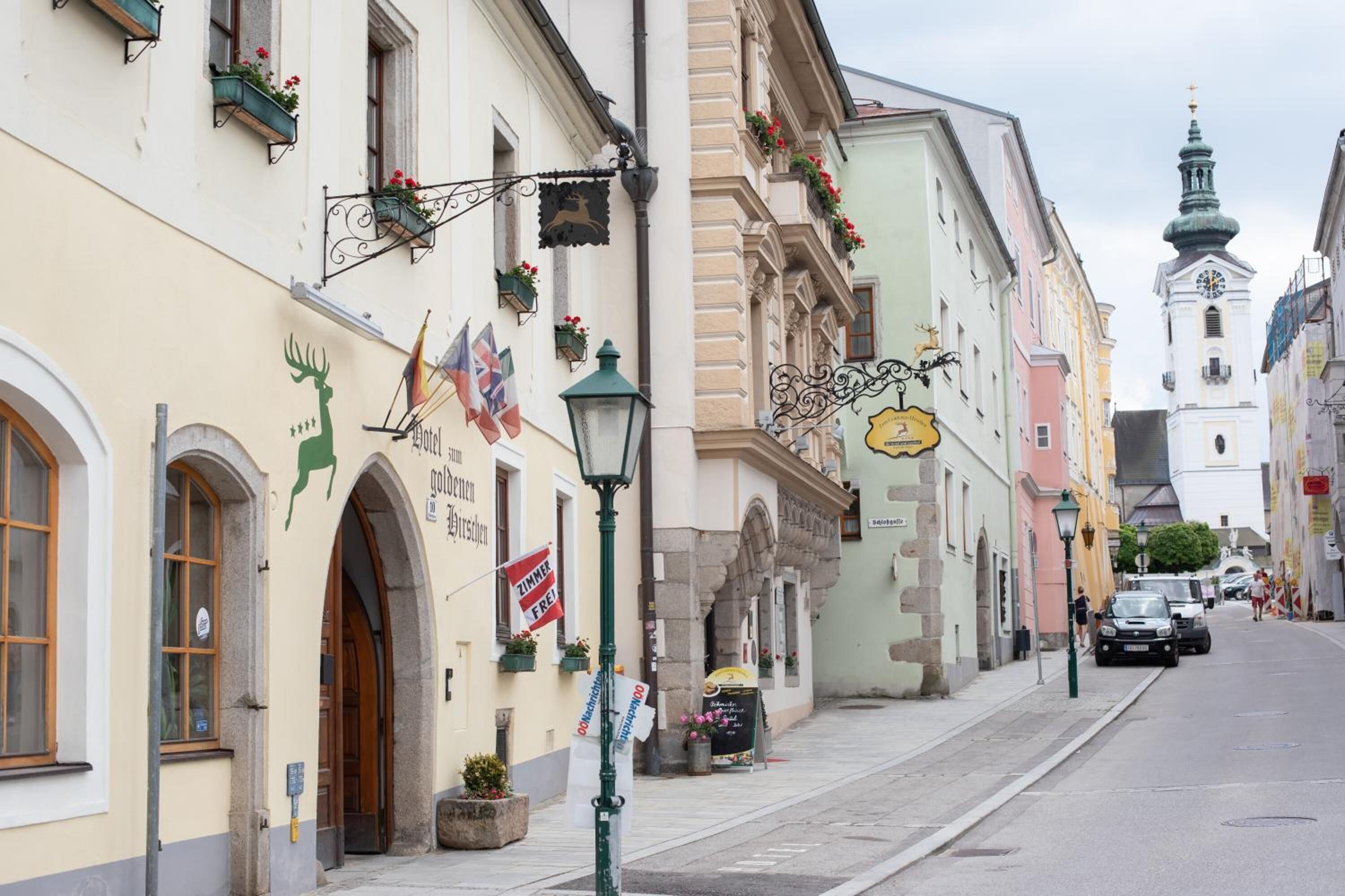 Eine Straße mit Gebäuden, einem Laternenpfahl und einem Kirchturm.