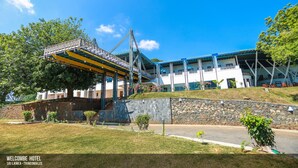 A hotel with a covered outdoor area, stone walls, and a clear blue sky. - Welcombe Hotel (Trincomalee)