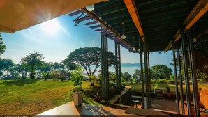 A modern hotel with a covered outdoor area, a view of the sea, and a well-maintained garden. - Welcombe Hotel (Trincomalee)