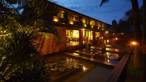 A modern hotel with a pool, surrounded by lush greenery and palm trees. - EKHO Lake Polonnaruwa (Polonnaruwa)