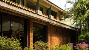 A building with a tiled roof, multiple air conditioning units, and potted plants in front. - EKHO Lake Polonnaruwa (Polonnaruwa)
