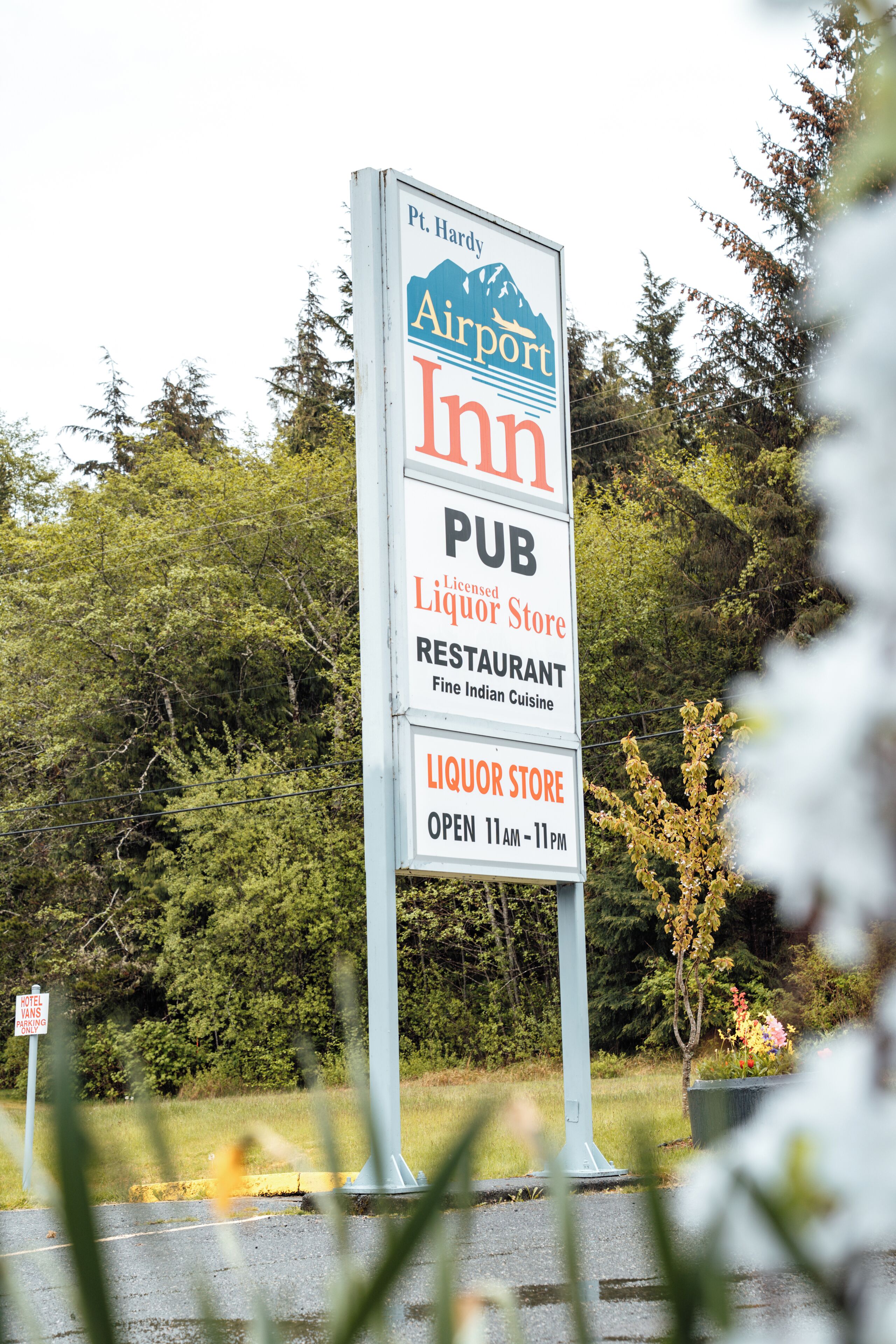 Une enseigne indiquant un hôtel près de l’aéroport, avec un pub et une boutique de vente de boissons alcoolisées, précisant qu’il s’agit d’un établissement agréé pour la vente de boissons alcoolisées et qui dispose également d’un restaurant.