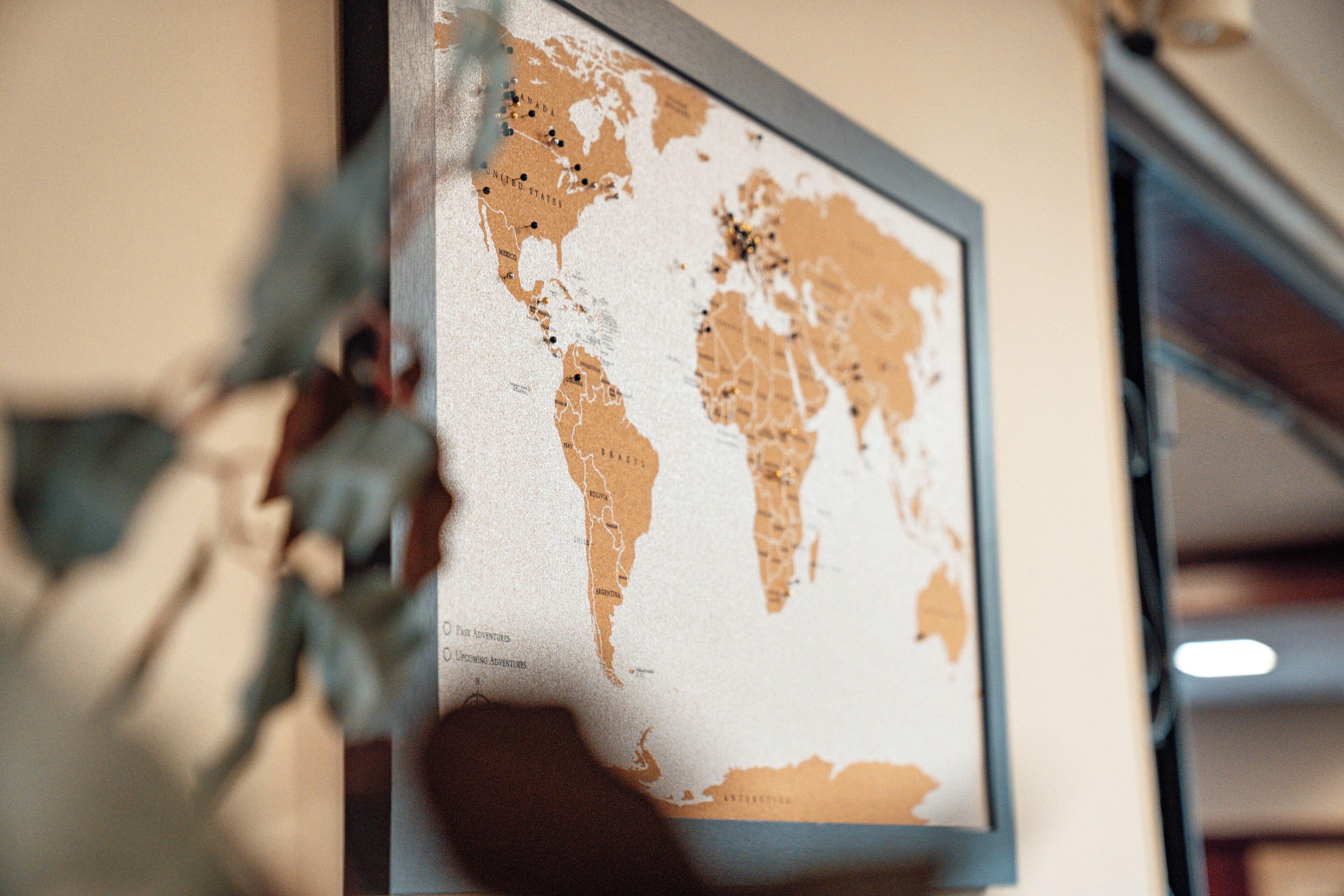 A framed world map with visible continents and some marked locations.