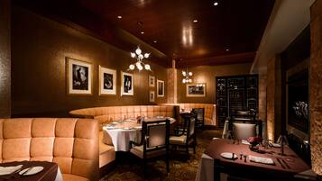 A restaurant with booth seating, tables, and a wine rack.