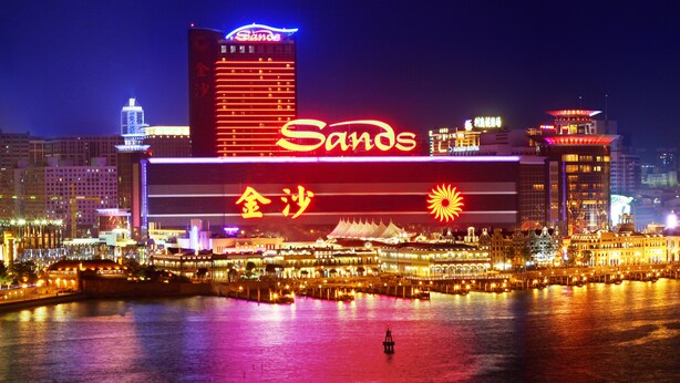 A hotel with a prominent 'Sands' sign, waterfront location, and a large illuminated logo. - Sands Macao (Macau)