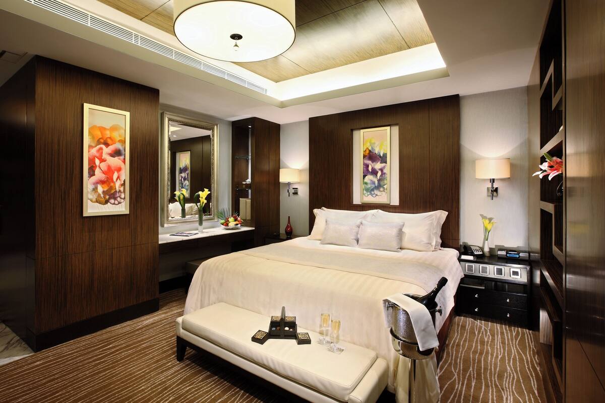 A hotel room with a large bed, bedside tables, a desk, and a chair.