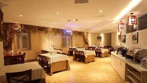 Un vaste espace dédié à la salle à manger, avec de nombreuses tables et chaises, un buffet et des rideaux décoratifs.