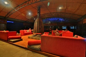 A spacious lounge area with red sofas and a central fire feature. - The Rainforest Ecolodge Sinharaja (Deniyaya)