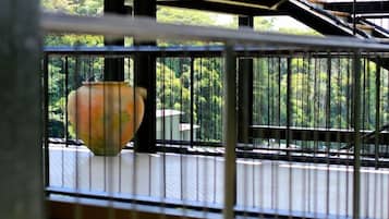 A metal staircase with a railing, leading to an outdoor area with greenery.