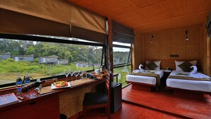 A room with two beds, a wooden desk with a view, and a large window overlooking greenery. - The Rainforest Ecolodge Sinharaja (Deniyaya)