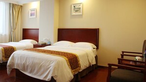 A hotel room with two beds, a wooden headboard, a chair, a nightstand, and a framed picture on the wall. - Green Tree Inn Express (Weihai)
