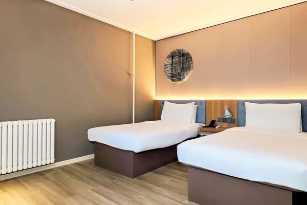 A modern hotel room with two beds, a wall-mounted light fixture, and a white radiator. - Home Inn (Weihai Kunming Road Tourist Dock Weigao Plaza) (Weihai)