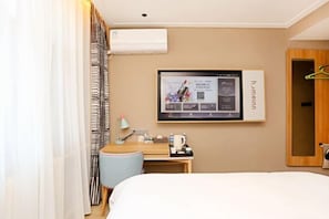A hotel room with a bed, a desk with a chair, a TV mounted on the wall, and a coat rack. - Home Inn (Weihai Kunming Road Tourist Dock Weigao Plaza) (Weihai)