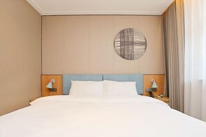 A hotel room with a bed, two bedside lamps, a wall-mounted light fixture, and a curtain. - Home Inn (Weihai Kunming Road Tourist Dock Weigao Plaza) (Weihai)