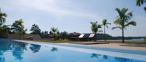 Una piscina al aire libre, tumbonas