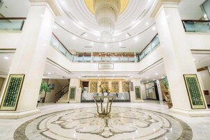 A spacious lobby with a central fountain, multiple floors, and a grand staircase.
