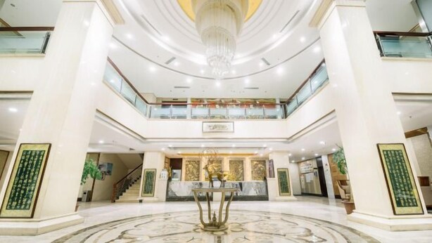 A spacious lobby with a central fountain, high ceilings, and a chandelier. - Yuanfeng Hebei Hotel (Lhasa)