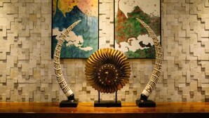A wall with a mosaic pattern and three framed artworks depicting abstract designs. - Yuanfeng Hebei Hotel (Lhasa)