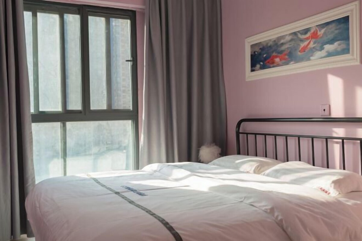 Quarto com uma cama, janela com cortinas e um quadro na parede.