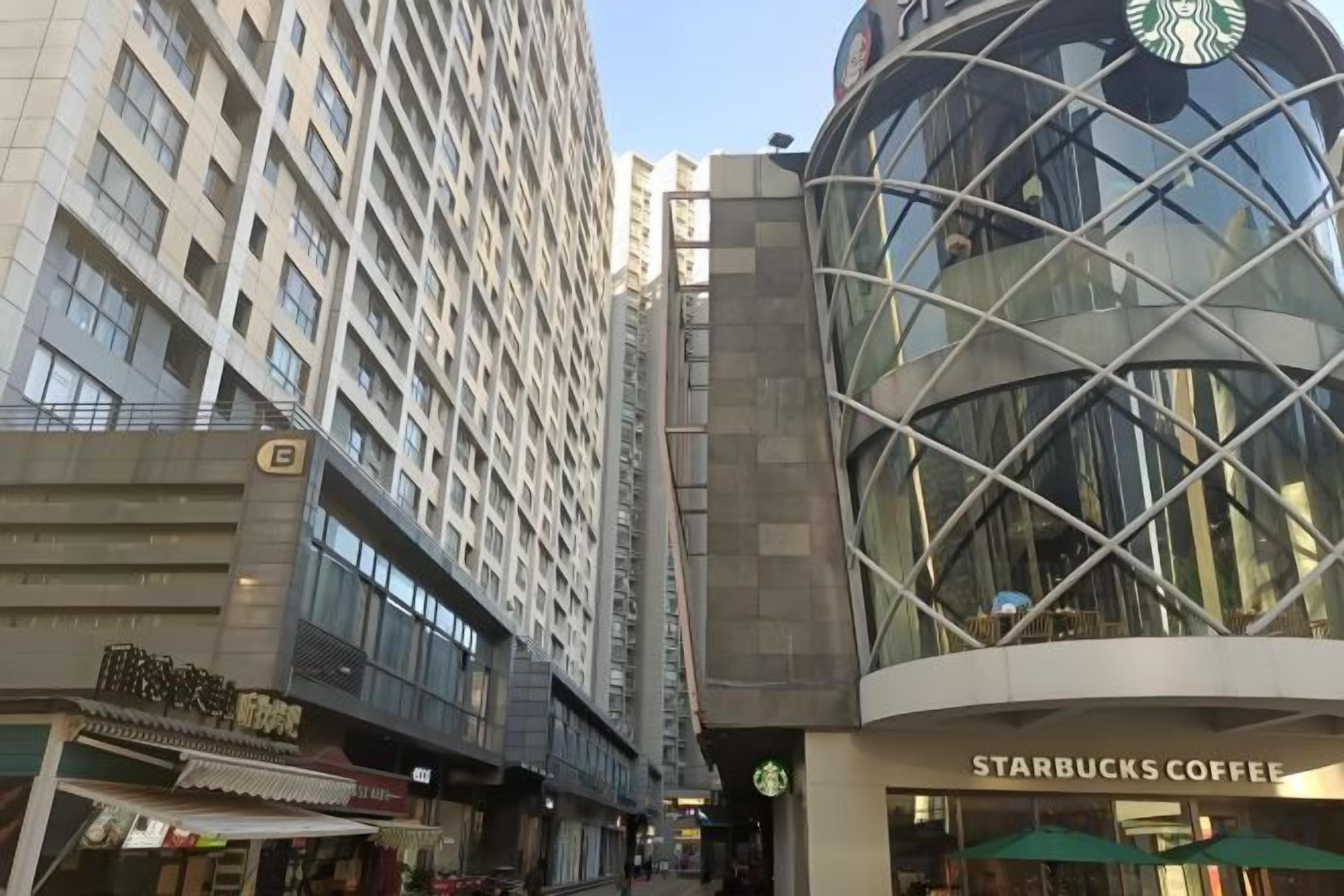 A multi-story building with a Starbucks Coffee sign, indicating a commercial area with shops on the ground floor.