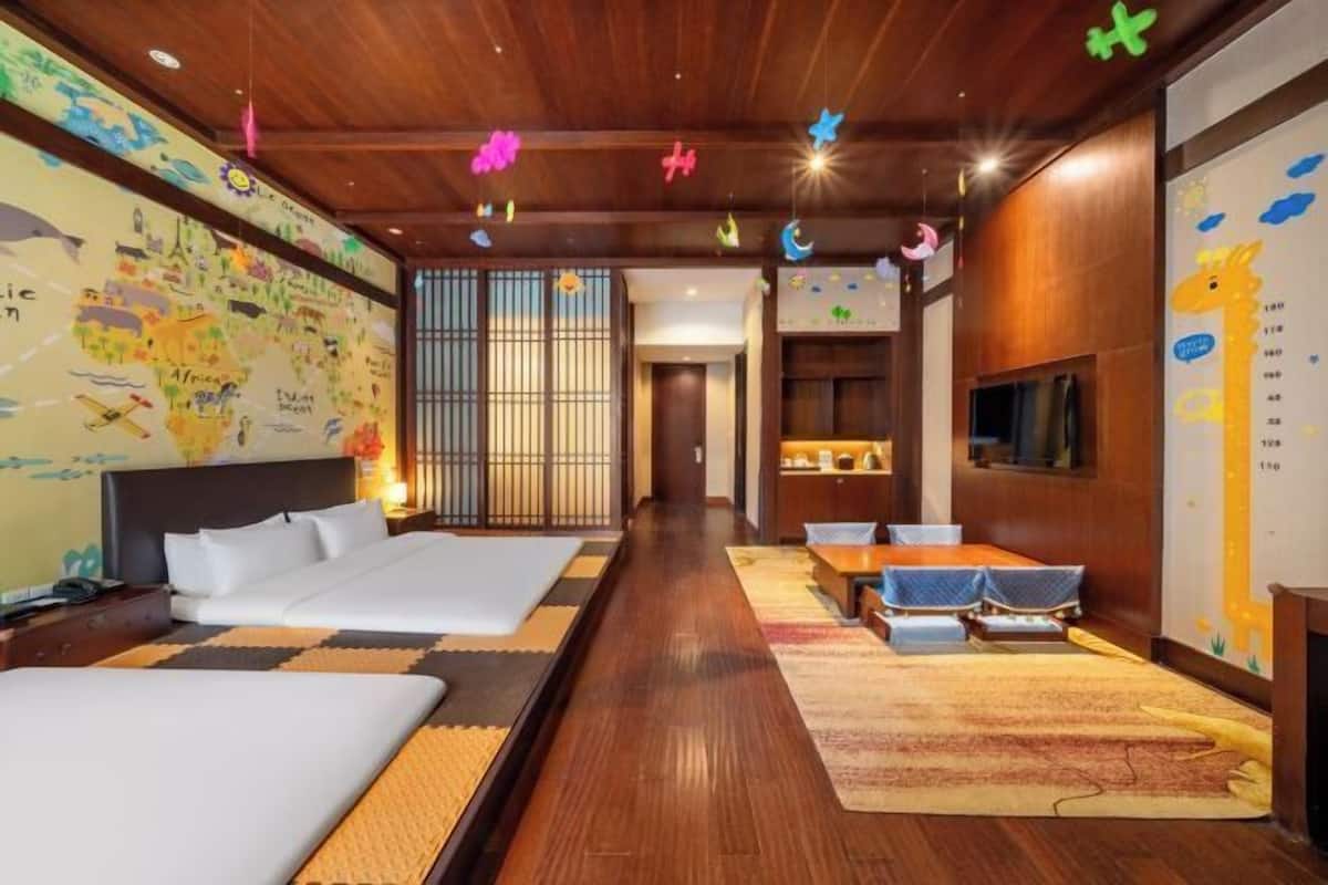 A hotel room with a large bed, a desk, and a TV.