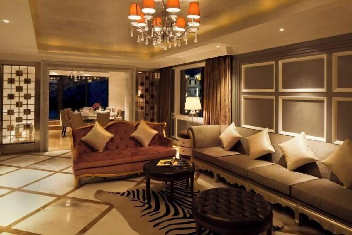 A modern living room with a red sofa, a beige sofa, and a zebra-patterned rug.