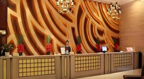 A reception desk with a modern design, a receptionist, and a digital screen. - Marco Polo Garden Hotel (Hangzhou)