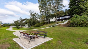 A park with a gravel path, benches, and a picnic table.