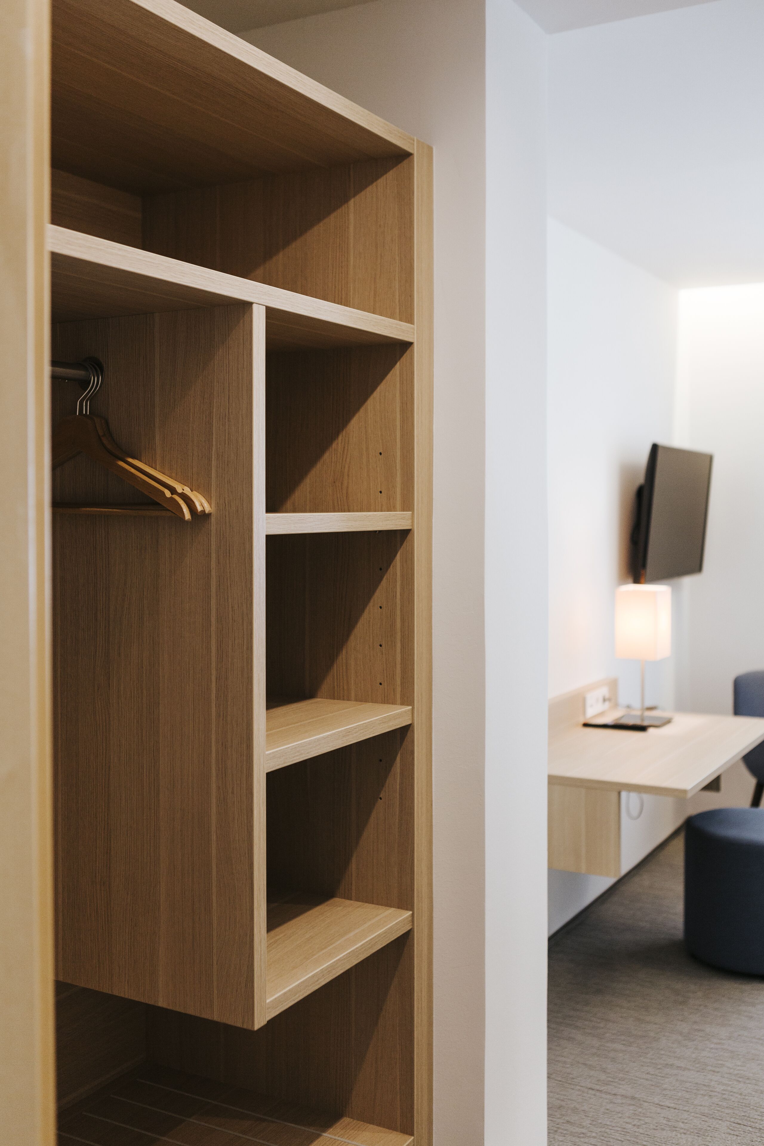 Ein Holzschrank mit mehreren Einlegeböden und Kleiderstange.