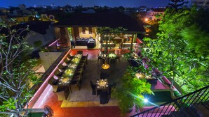 Un restaurant situé sur le toit, avec une terrasse, un bar et un escalier menant à l’étage supérieur.