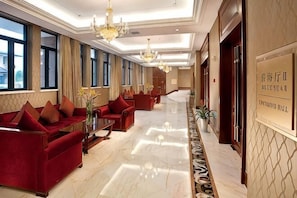 A hotel lobby with red sofas, a marble floor, chandeliers, and a reception desk. - Meiyuan Hotel (Ningbo)