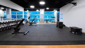 A gym with weightlifting equipment, cardio machines, and a wall-mounted TV. - Sommerhaus Linz (Linz)